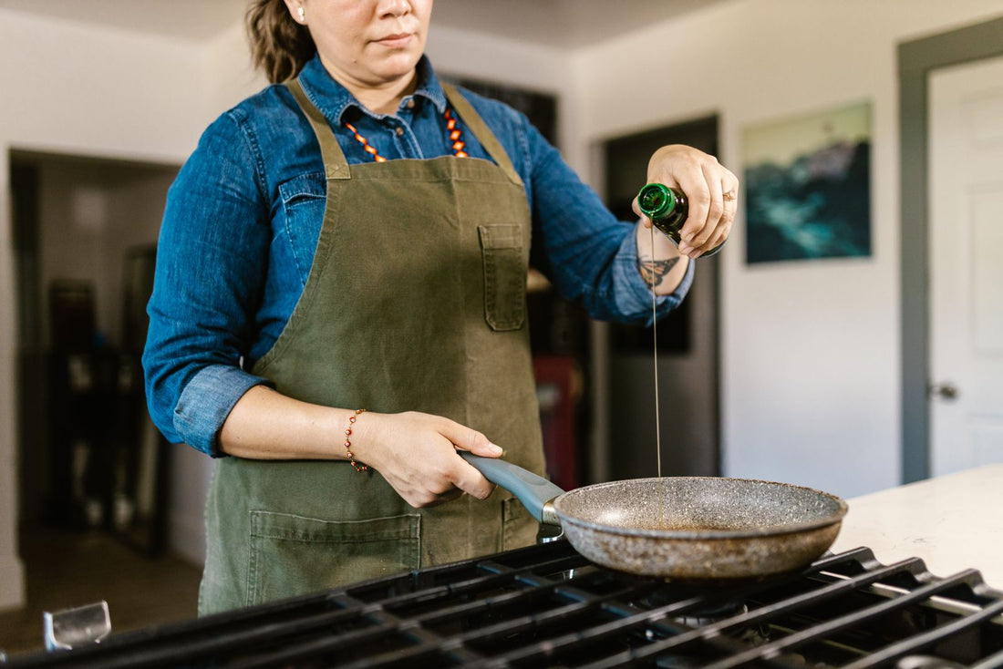 Olio extravergine di oliva versato in padella per la cottura e la frittura